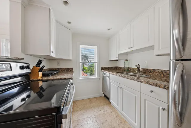 a kitchen with stainless steel appliances granite countertop a sink stove and cabinets