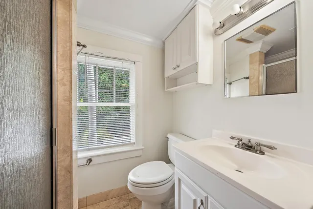 a bathroom with a granite countertop toilet a sink and a mirror