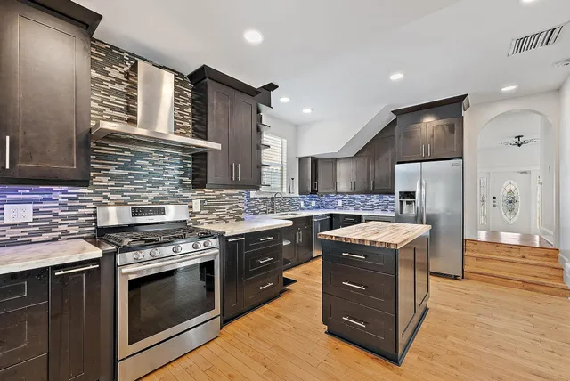 a kitchen with stainless steel appliances granite countertop wooden cabinets sink and stove
