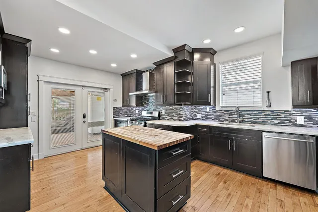 a large kitchen with stainless steel appliances granite countertop a sink and a stove