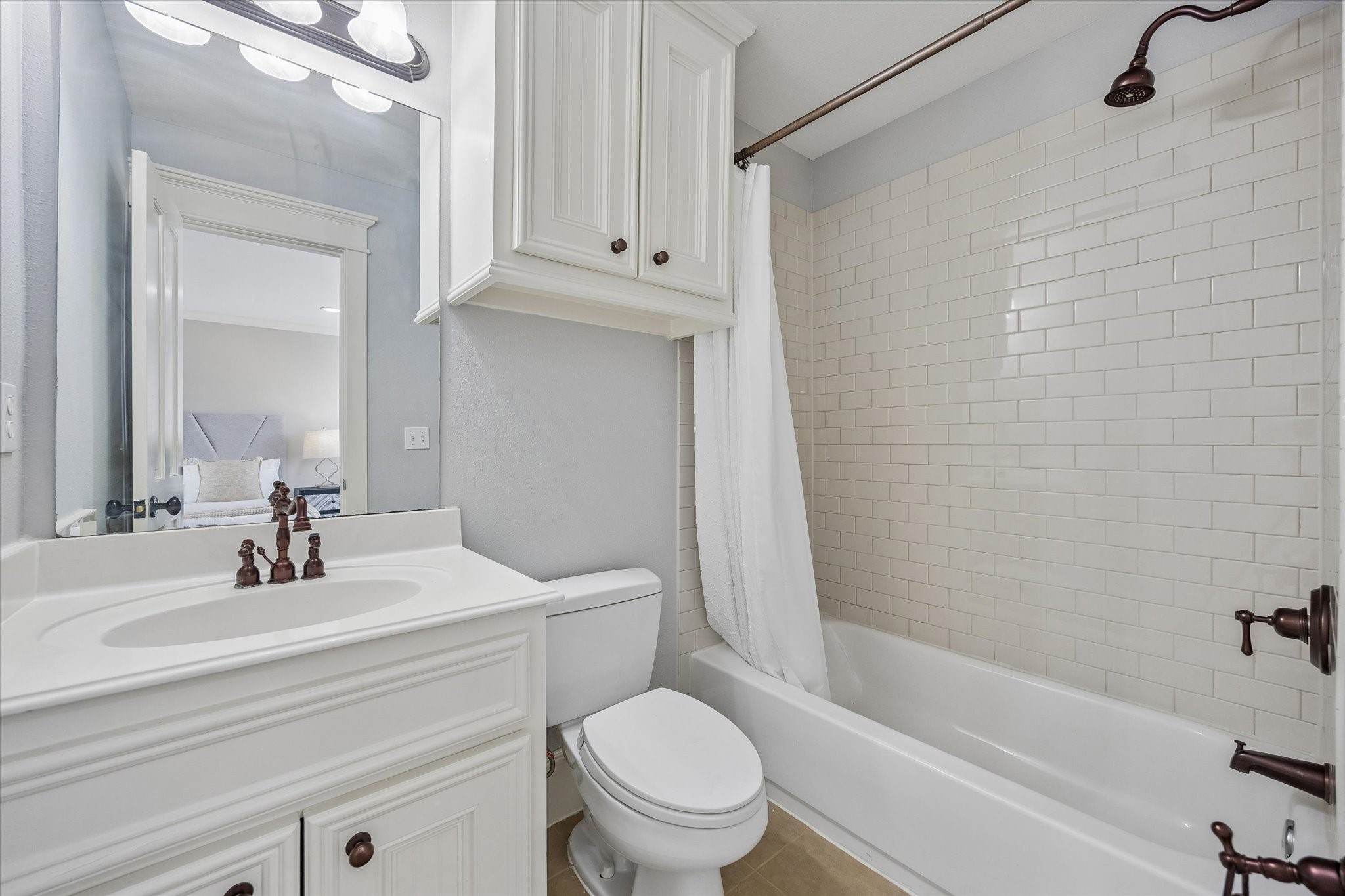 634 West 17th Street Houston, TX 77008 - Photo 33 of 42 This full bath adds comfort and convenience to the garage suite, with a single sink vanity, full mirror, and vanity lights above. Extra storage over the toilet and a tiled tub/shower combo complete the space with classic appeal and practical function.
