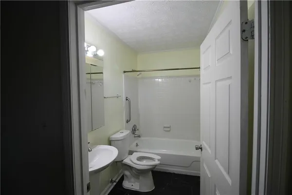 a bathroom with a granite countertop toilet a sink and shower