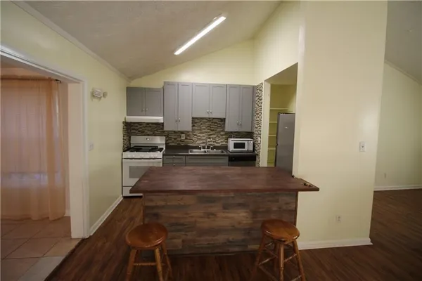 a kitchen with kitchen island a counter top space appliances and cabinets