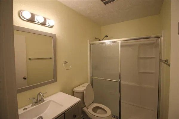 a bathroom with a sink mirror vanity and toilet