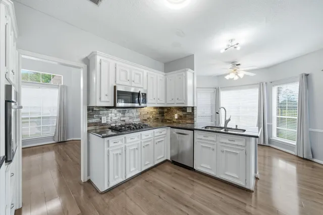 a kitchen with stainless steel appliances a sink stove and cabinets
