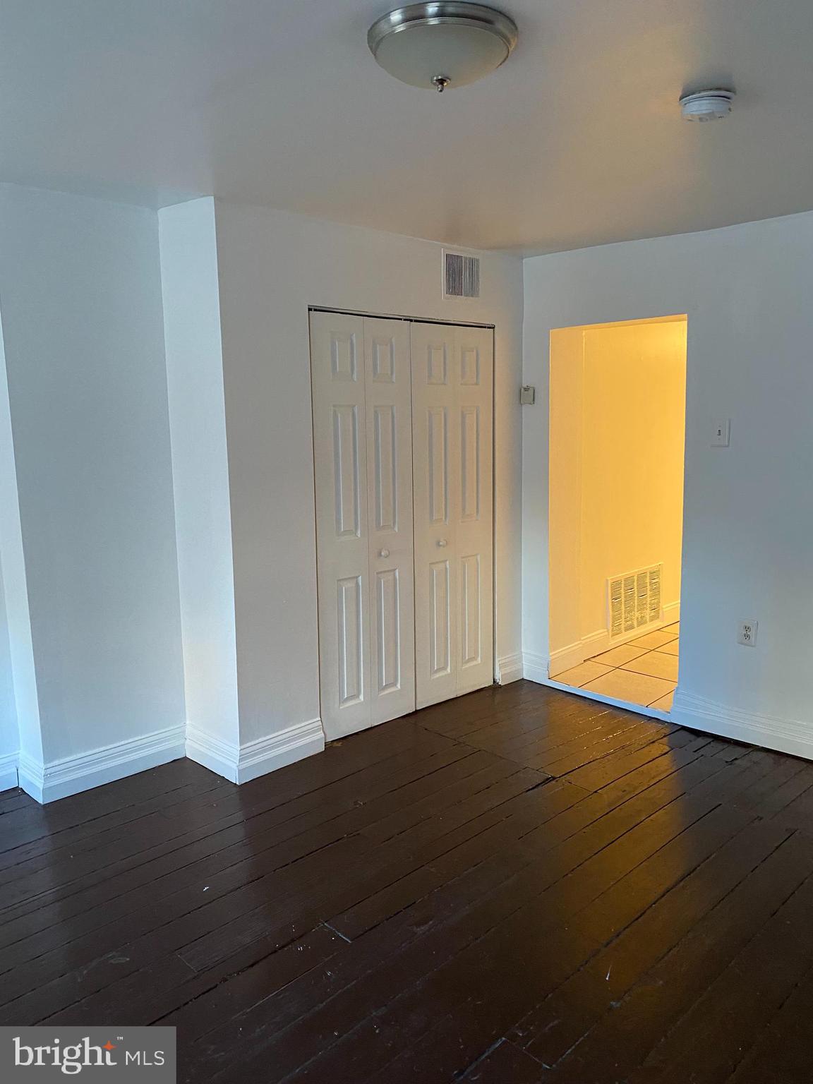 1012 South 12th Street, Unit 3 Philadelphia, PA 19147 - Photo 5 of 11 a view of an empty room with wooden floor and a window