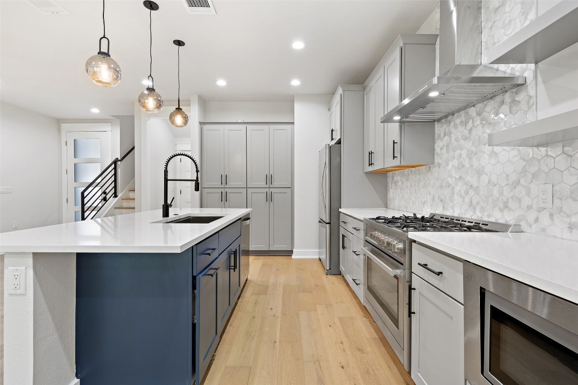 5109 Stone Gate Drive, Unit 2 Austin, TX 78721 - Photo 13 of 38 a kitchen with stainless steel appliances a sink stove and cabinets