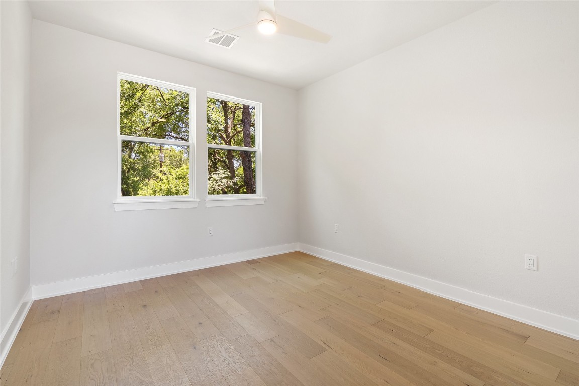 5109 Stone Gate Drive, Unit 2 Austin, TX 78721 - Photo 22 of 38 an empty room with wooden floor and windows