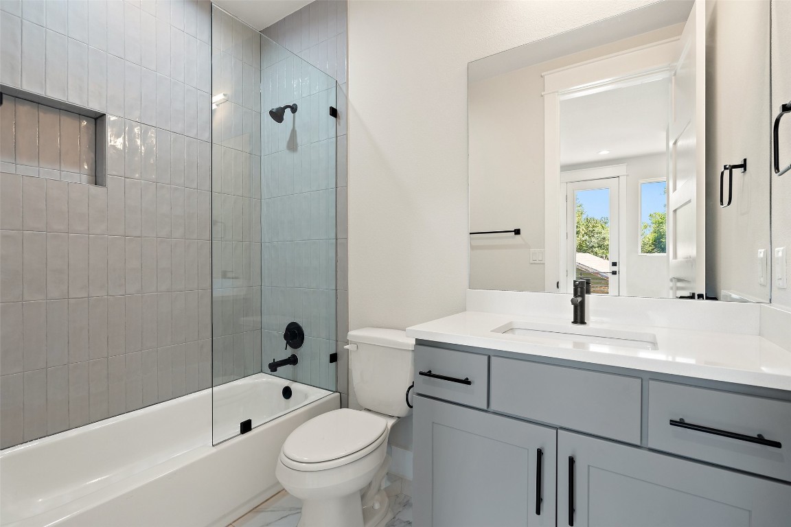 5109 Stone Gate Drive, Unit 2 Austin, TX 78721 - Photo 23 of 38 a bathroom with a sink a toilet and shower