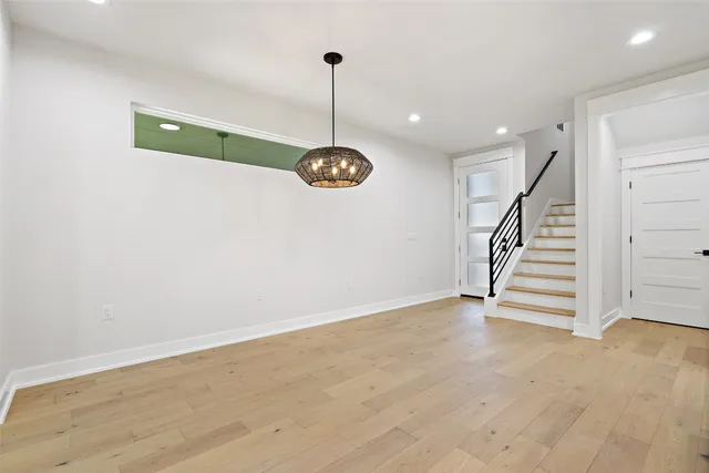 a view of room with stairs and wooden floor