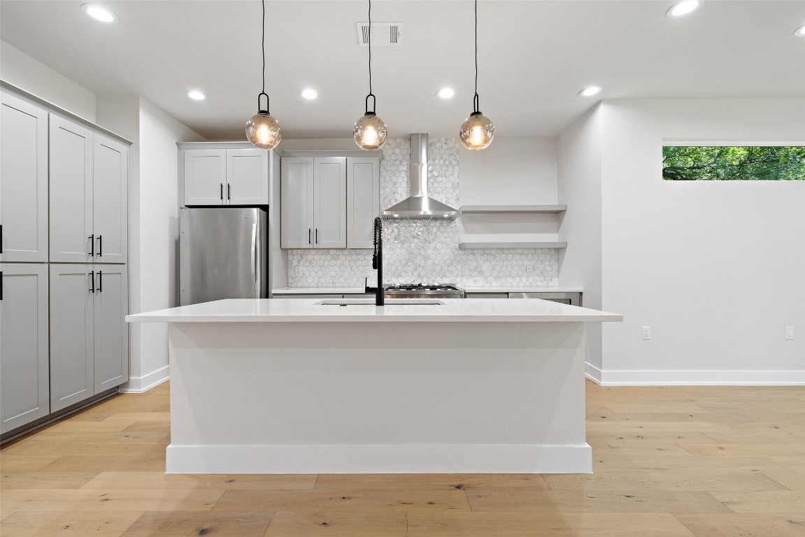 5109 Stone Gate Drive, Unit 2 Austin, TX 78721 - Photo 10 of 38 a large kitchen with stainless steel appliances a large counter top a refrigerator and a fireplace