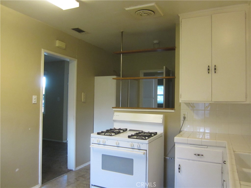 6725 De Anza Avenue Riverside, CA 92506 - Photo 11 of 25 a kitchen with a stove and a refrigerator