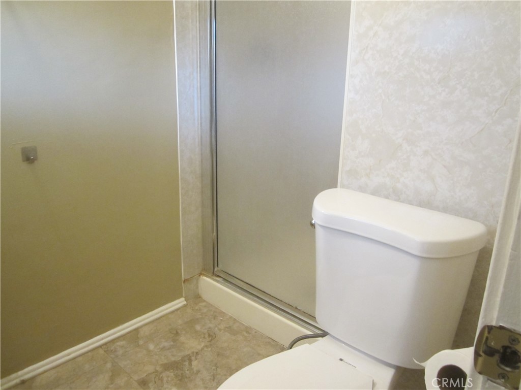 6725 De Anza Avenue Riverside, CA 92506 - Photo 15 of 25 a white toilet sitting next to a shower