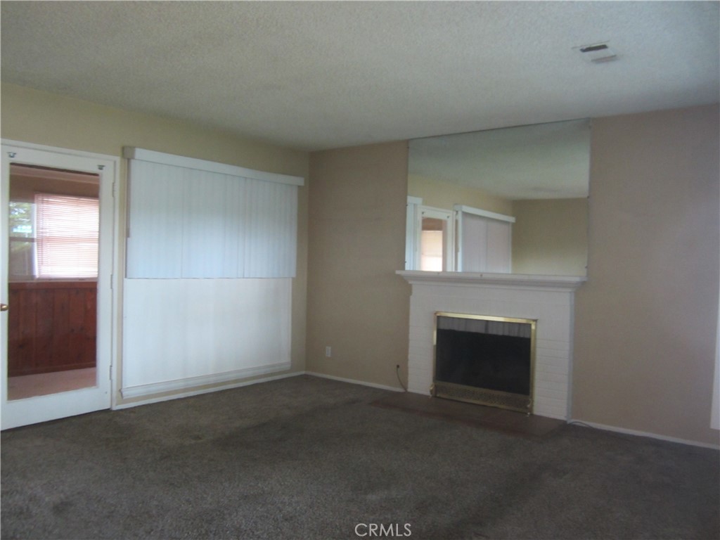 6725 De Anza Avenue Riverside, CA 92506 - Photo 3 of 25 an empty room with a fireplace and a window