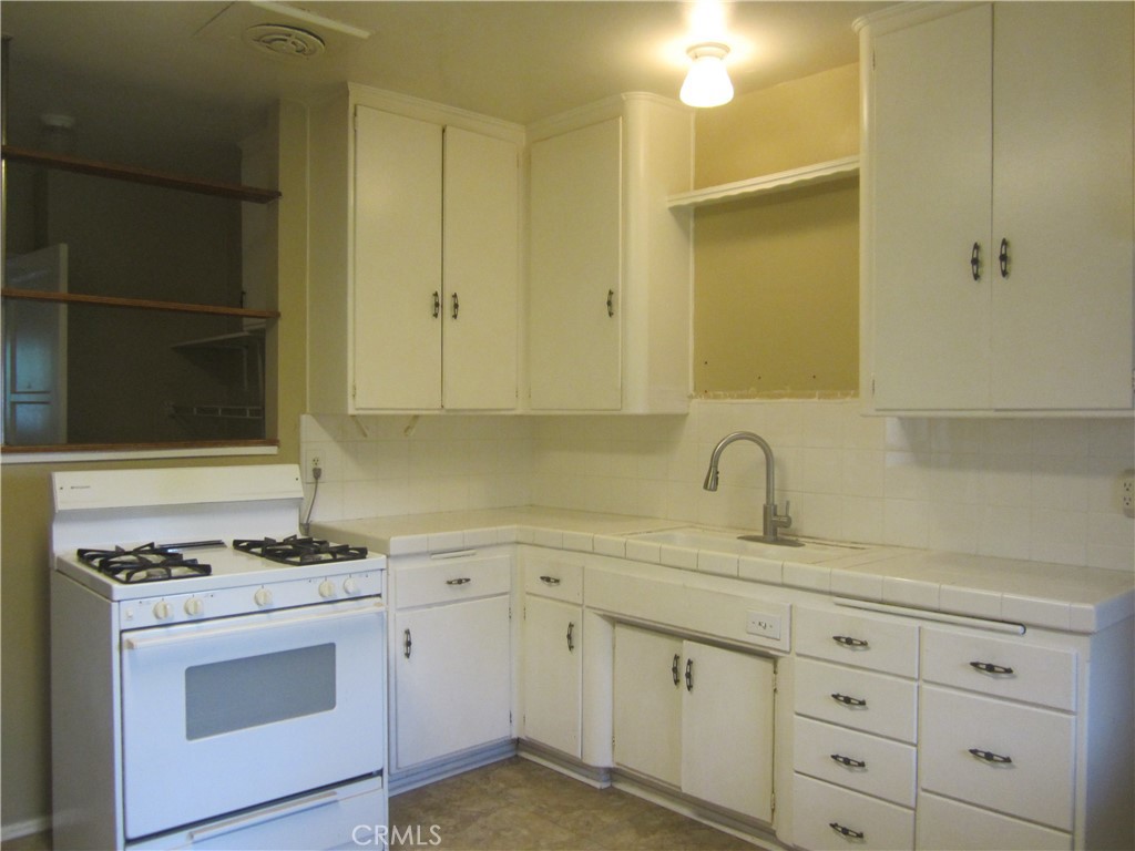 6725 De Anza Avenue Riverside, CA 92506 - Photo 10 of 25 a kitchen with white cabinets and white appliances