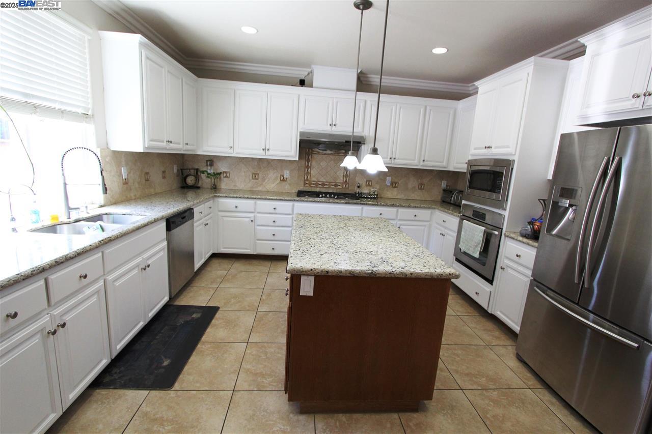 5199 Salerno Drive Dublin, CA 94568 - Photo 7 of 20 a large kitchen with stainless steel appliances granite countertop a stove a sink and a refrigerator