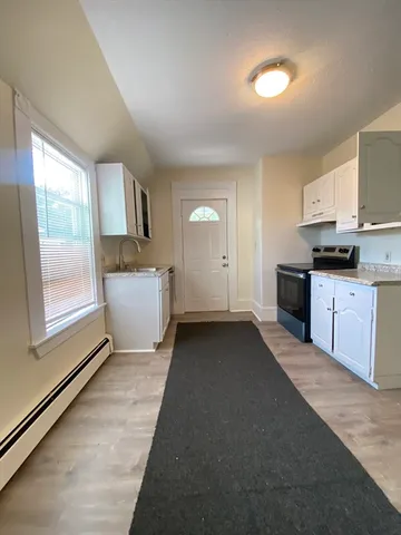 a view of a kitchen with a sink dishwasher oven and a kitchen island