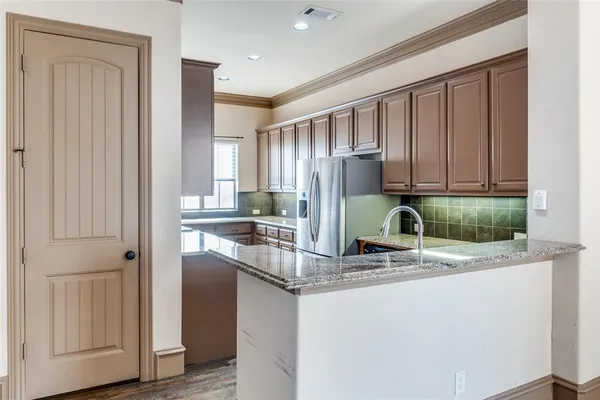 a kitchen with stainless steel appliances granite countertop a refrigerator and a sink