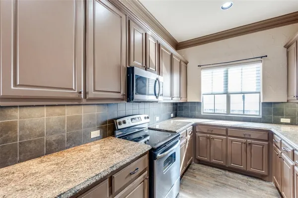 a kitchen with stainless steel appliances granite countertop a sink stove and cabinets