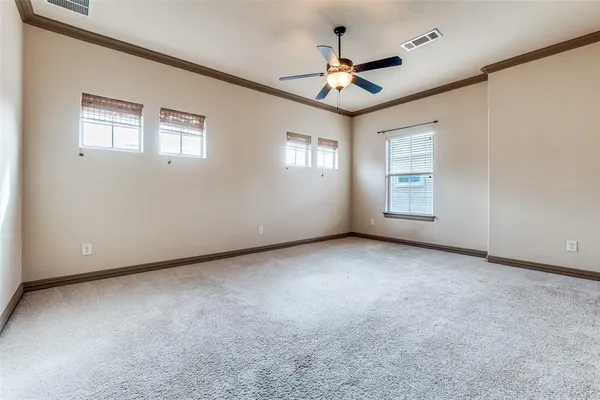 an empty room with windows and ceiling fan