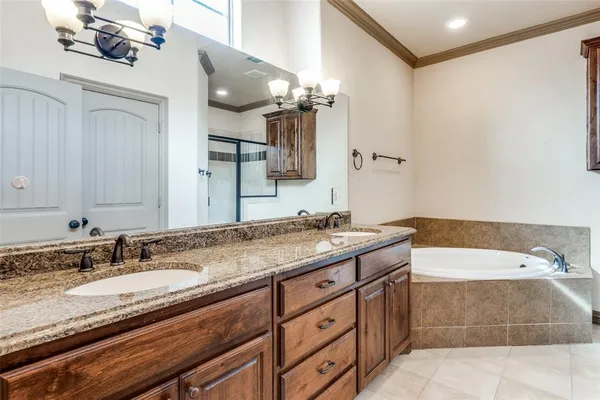 a bathroom with a granite countertop double vanity sink and mirror