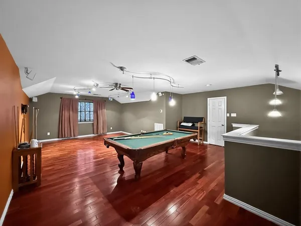 a living room with furniture a pool table and a fireplace