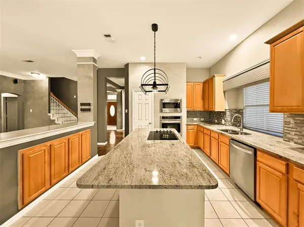 a large kitchen with kitchen island granite countertop a large counter top and stainless steel appliances