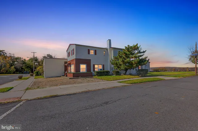 a view of a house with a yard and a street