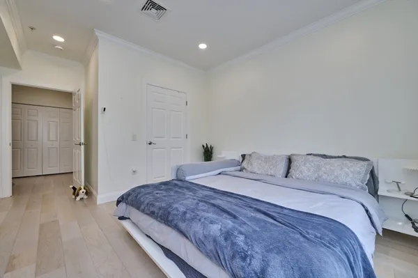 a bedroom with a large bed and a chandelier