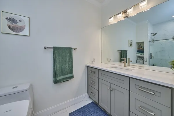 a bathroom with a double vanity sink a mirror and a toilet