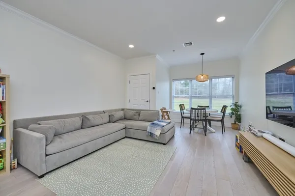 a living room with furniture kitchen view and a large window
