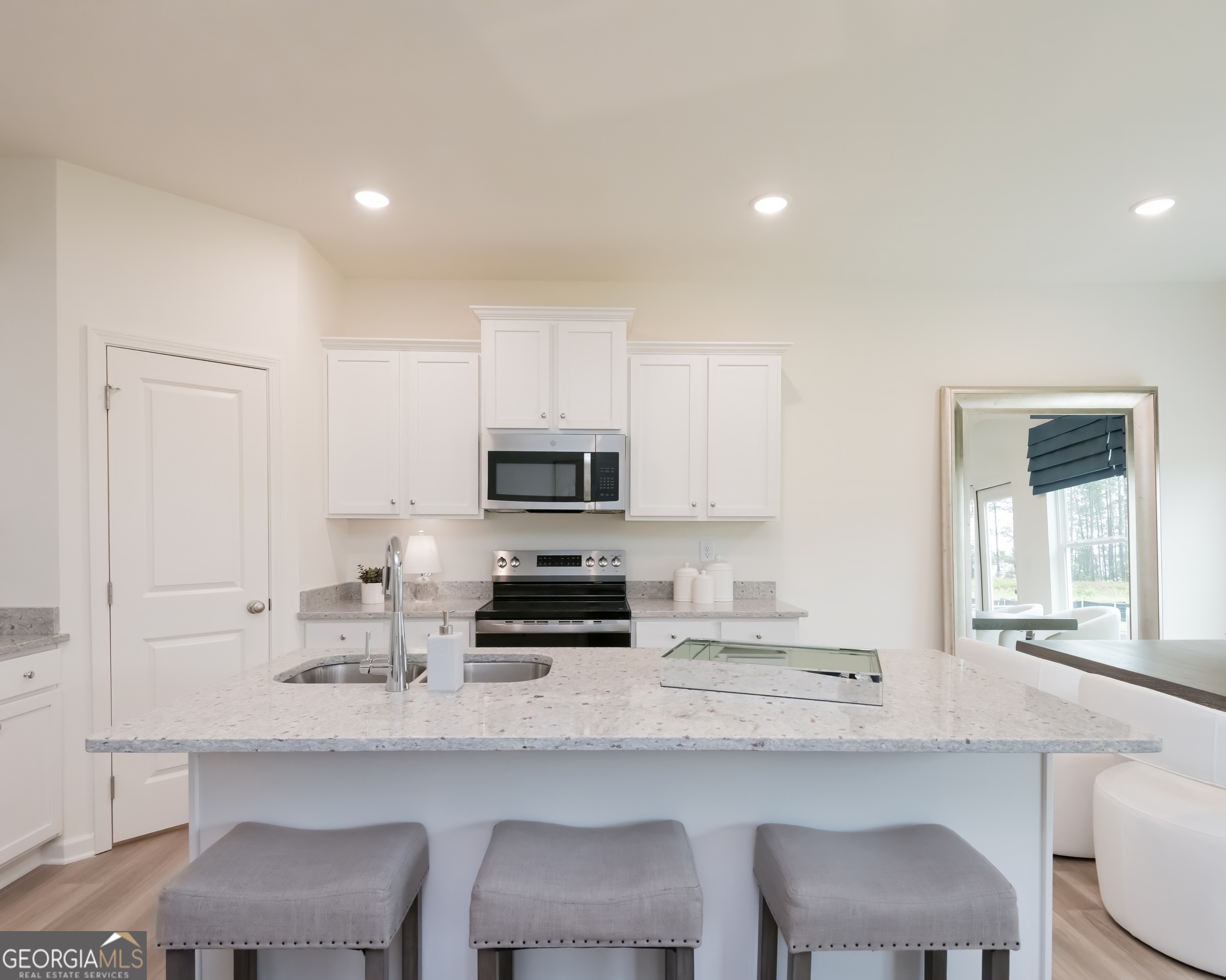 2553 Riverside Court Northeast Conyers, GA 30013 - Photo 12 of 40 a kitchen with stainless steel appliances a white table and chairs in it