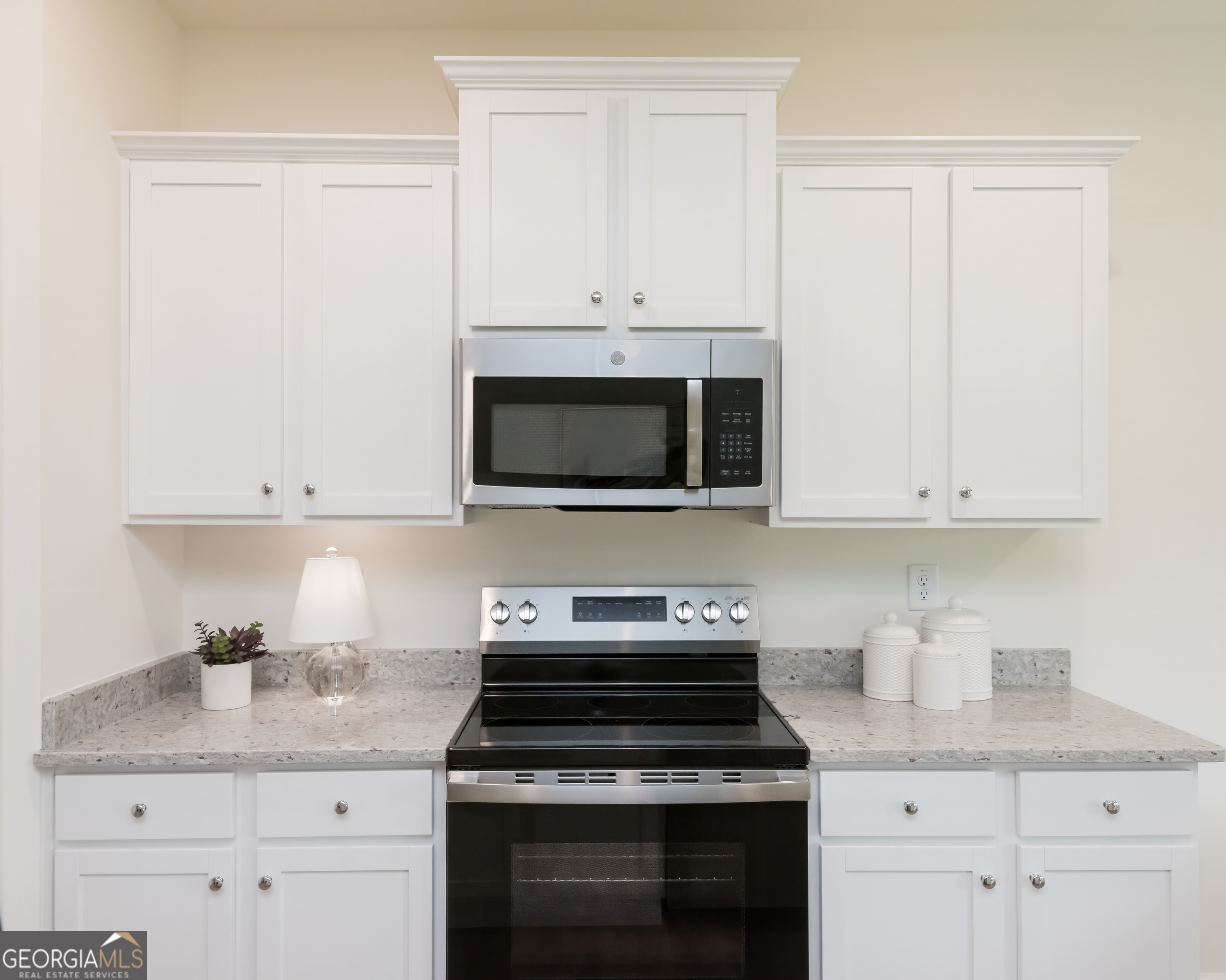 2553 Riverside Court Northeast Conyers, GA 30013 - Photo 14 of 40 a kitchen with granite countertop white cabinets and stainless steel appliances