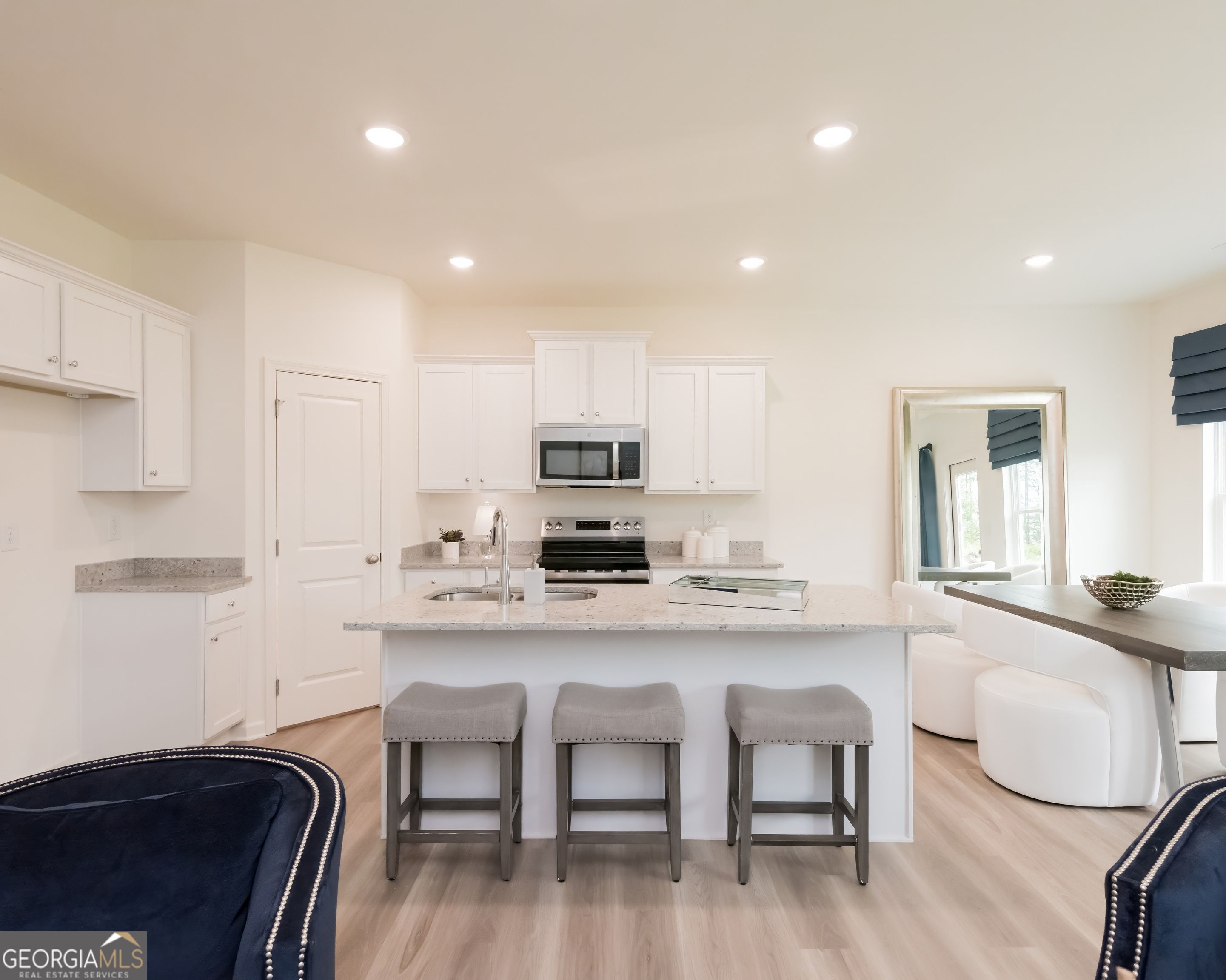 2553 Riverside Court Northeast Conyers, GA 30013 - Photo 6 of 40 a kitchen with stainless steel appliances granite countertop a stove a sink a microwave a refrigerator white cabinets and chairs