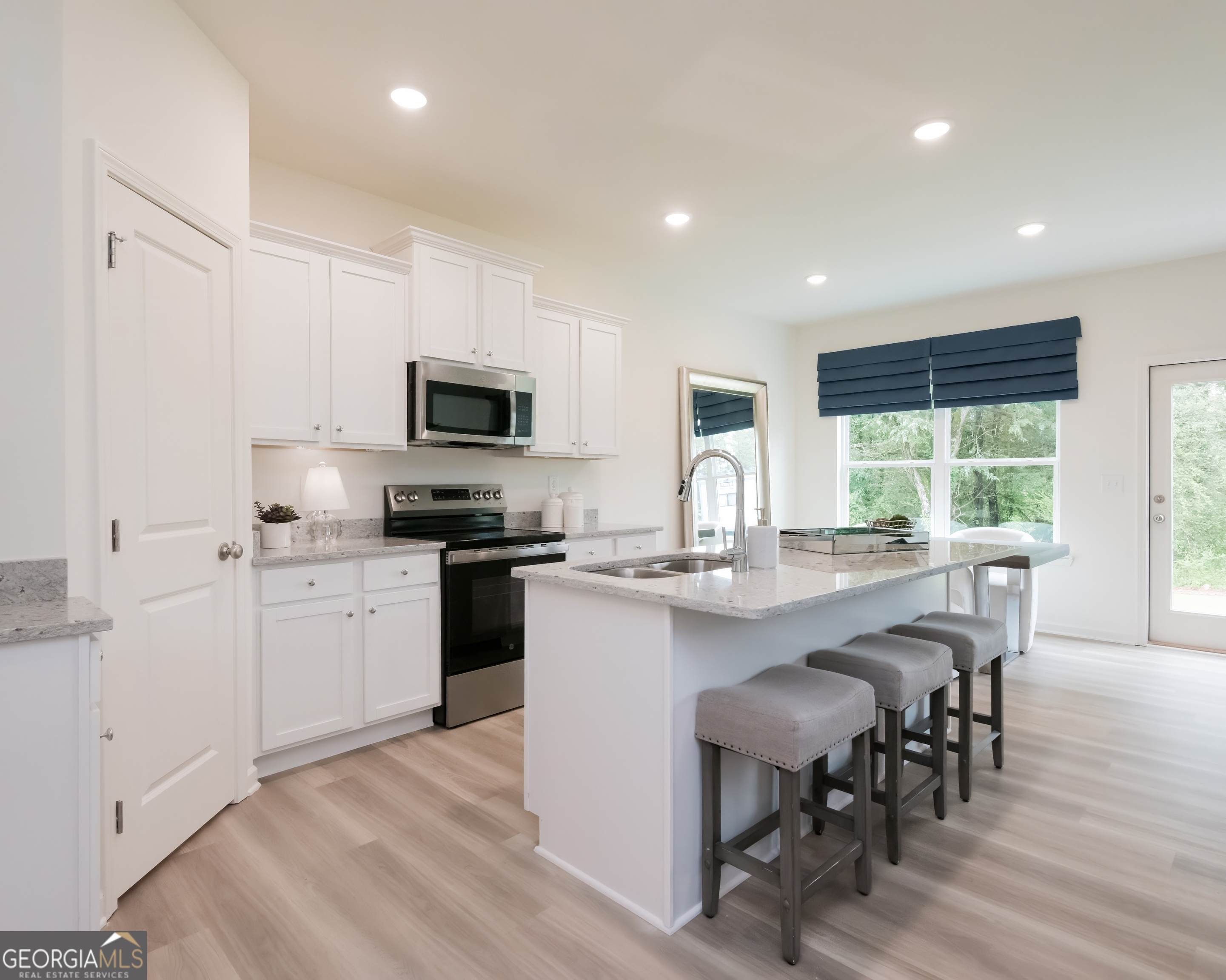 2553 Riverside Court Northeast Conyers, GA 30013 - Photo 8 of 40 a kitchen with microwave a stove top oven a sink a dining table and chairs
