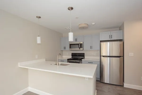 a kitchen with stainless steel appliances a refrigerator a sink a stove a microwave and island