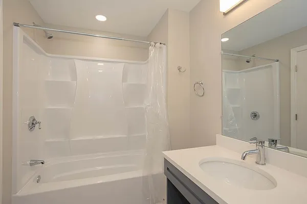 a bathroom with a sink shower and a mirror