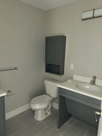 a bathroom with a toilet a sink and mirror