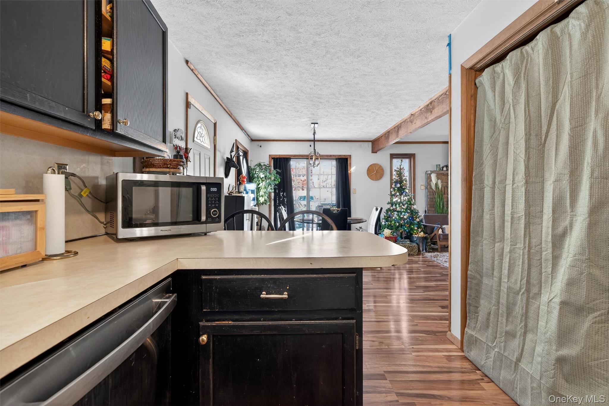 3111 Cherry Ridge Road Bushkill, PA 18324 - Photo 14 of 29 Kitchen featuring dark cabinetry, stainless steel appliances, a textured ceiling, light countertops, and dark wood-type flooring