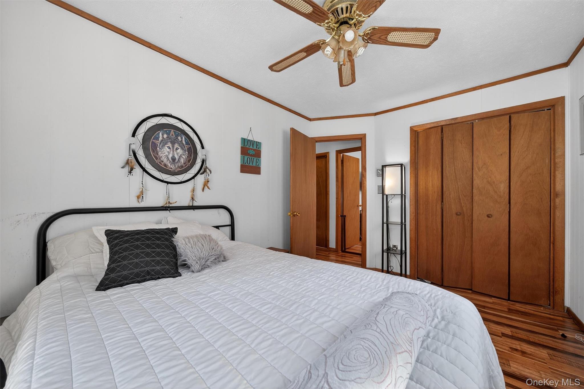 3111 Cherry Ridge Road Bushkill, PA 18324 - Photo 19 of 29 Bedroom with crown molding, a ceiling fan, wood finished floors, and a closet