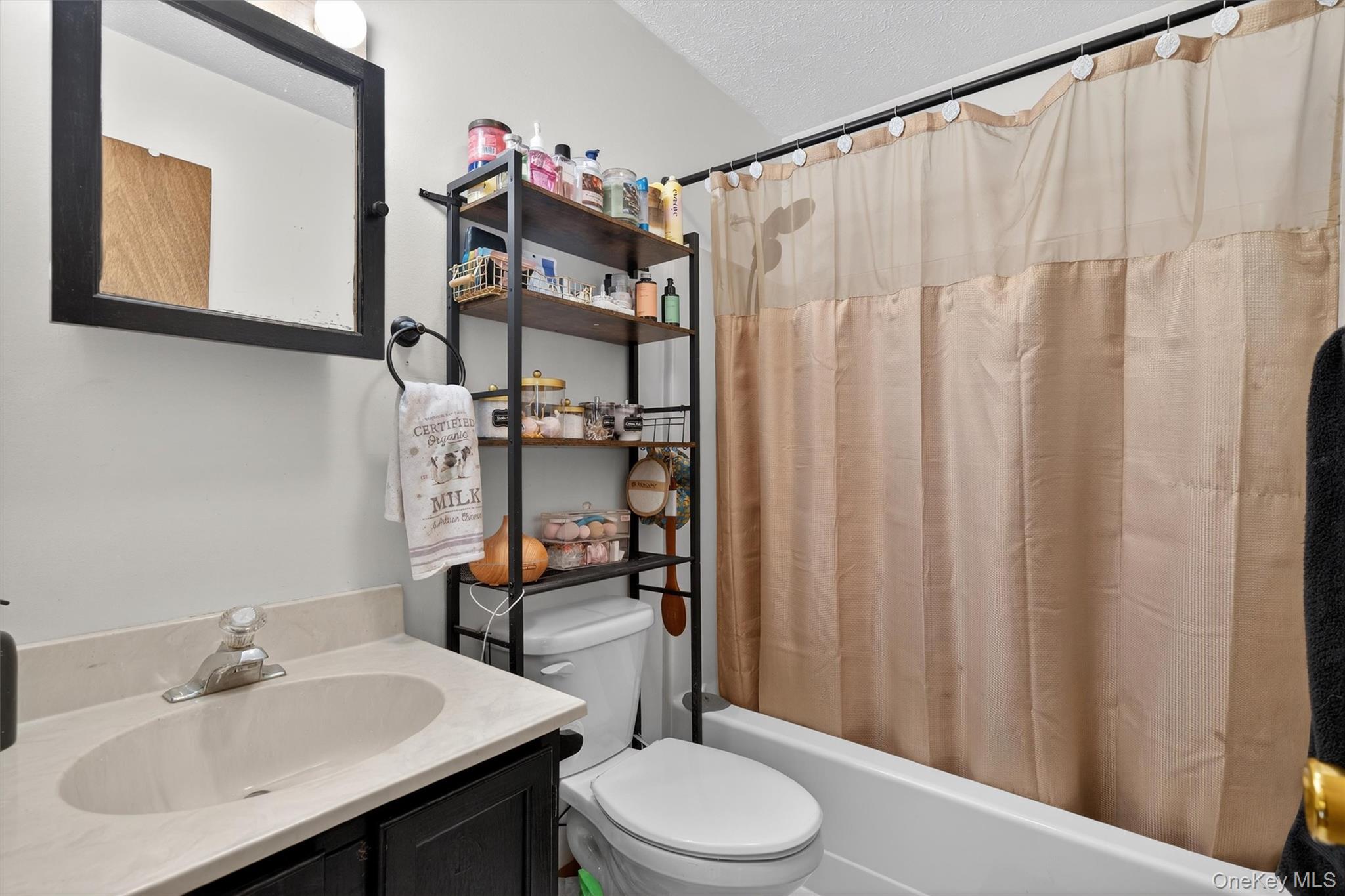 3111 Cherry Ridge Road Bushkill, PA 18324 - Photo 26 of 29 Bathroom with shower / bathtub combination with curtain, vanity, and a textured ceiling