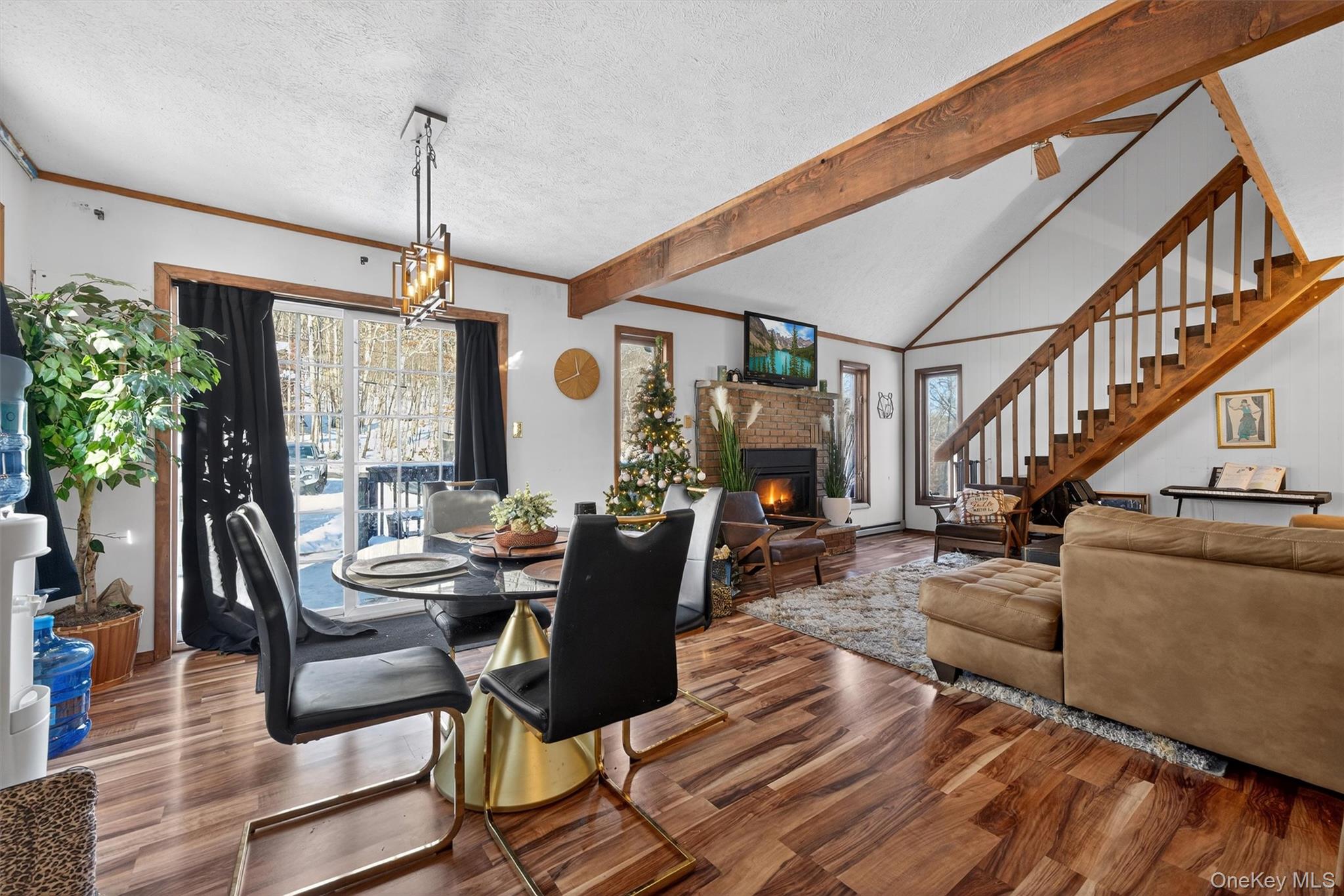 3111 Cherry Ridge Road Bushkill, PA 18324 - Photo 5 of 29 Dining area with a textured ceiling, healthy amount of natural light, a fireplace, wood finished floors, and crown molding