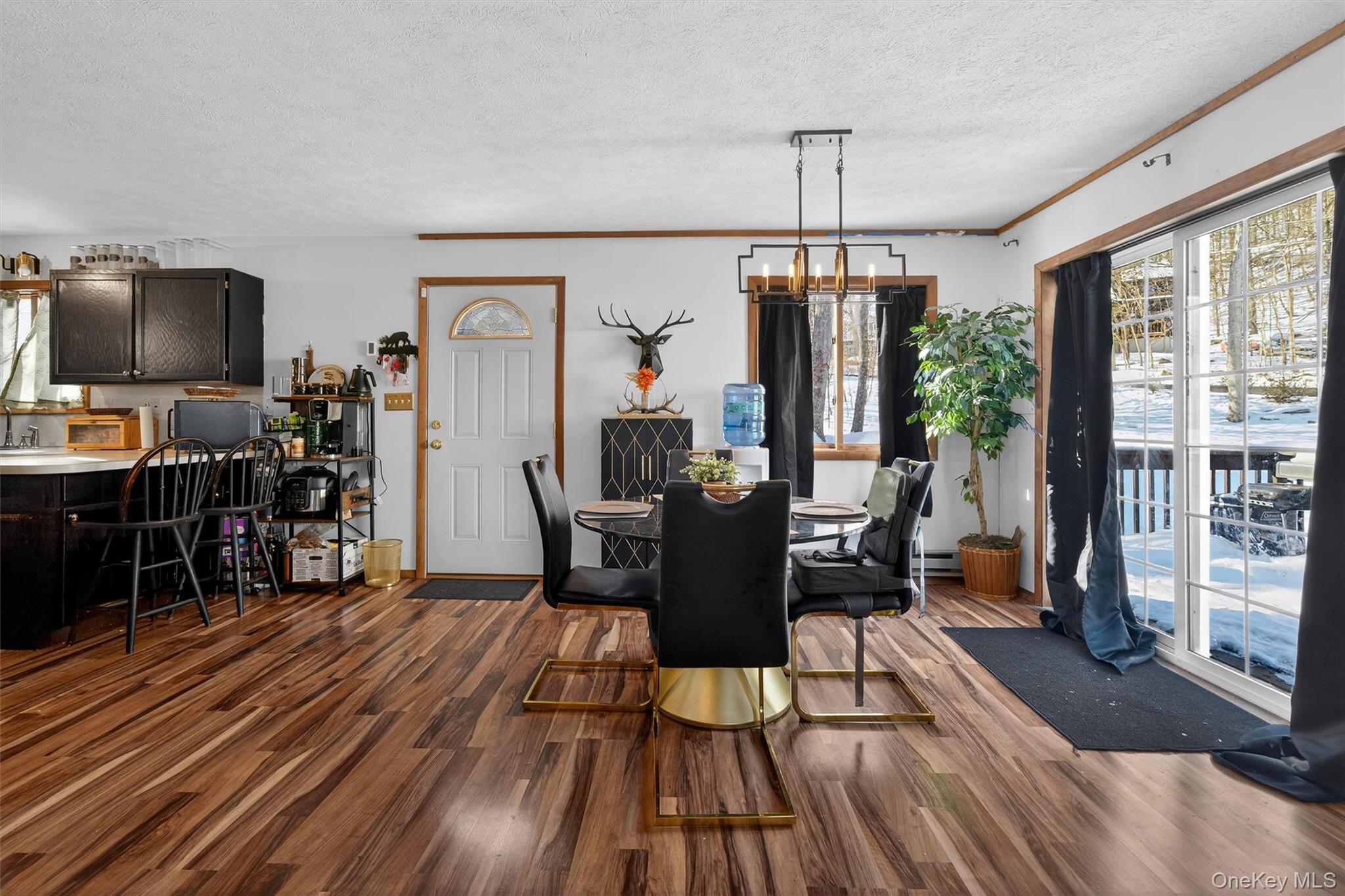 3111 Cherry Ridge Road Bushkill, PA 18324 - Photo 7 of 29 Dining room with plenty of natural light, dark wood finished floors, a textured ceiling, a chandelier, and ornamental molding