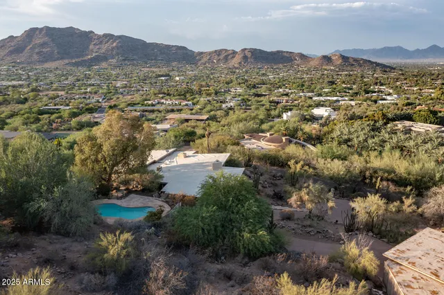 an aerial view of residential houses with outdoor space and trees