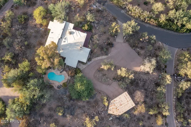 an aerial view of a house with a yard and a large tree