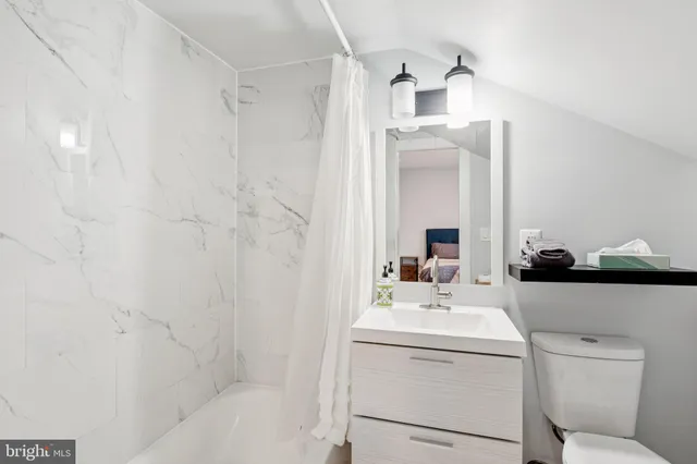 a bathroom with a sink a toilet and shower curtain