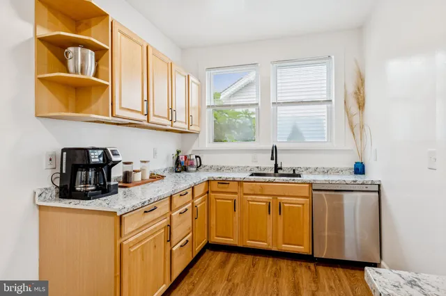a kitchen with stainless steel appliances granite countertop a sink a stove cabinets and wooden floor