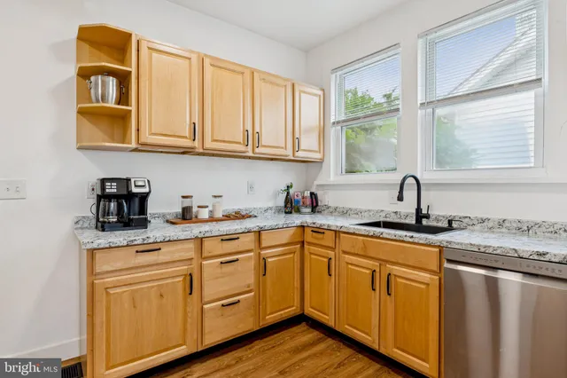 a kitchen with stainless steel appliances granite countertop a sink and cabinets with wooden floor