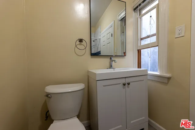a bathroom with a toilet sink and mirror