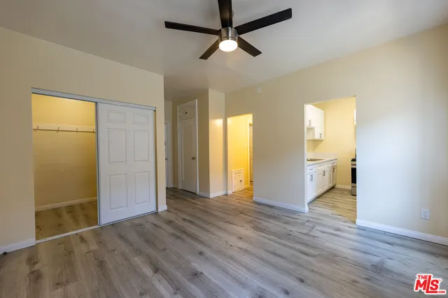 a view of an empty room with wooden floor and a window